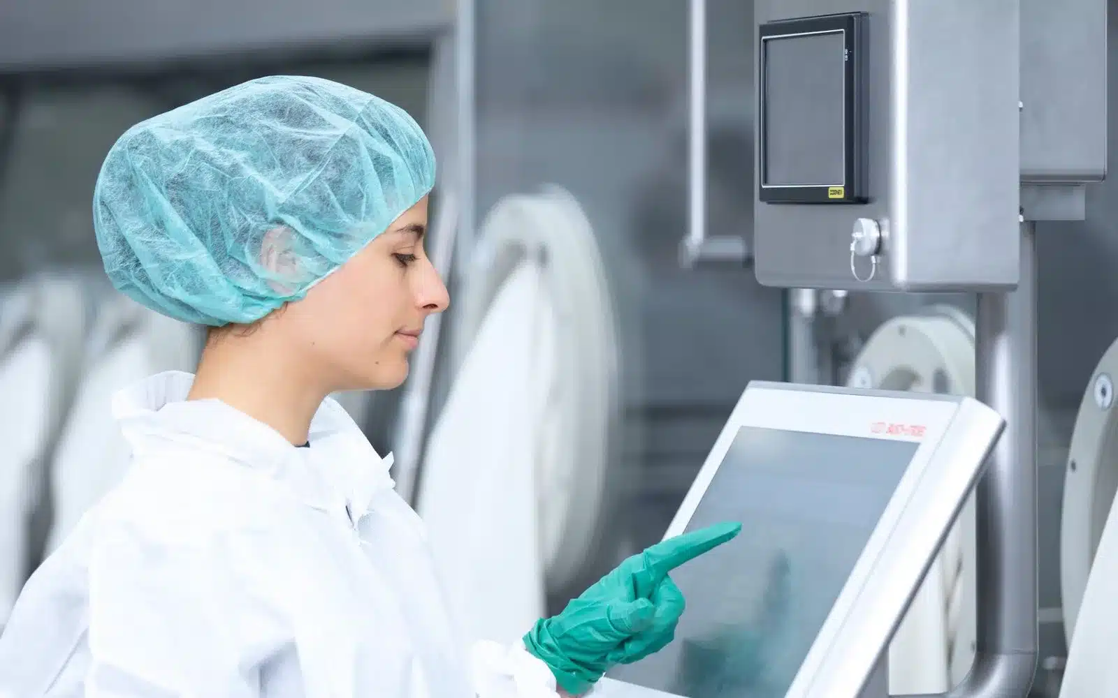 Mitarbeiterin bedient eine Bausch+Ströbel Anlage per Touchpanel