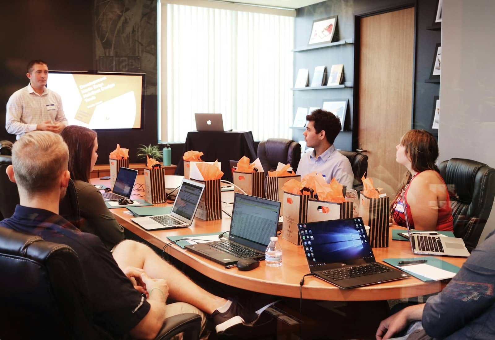 Salesforce Account Engagement Beratung von Beyond Digital: Präsentation in einem Besprechungsraum, Teilnehmende sitzen mit Laptops am Tisch