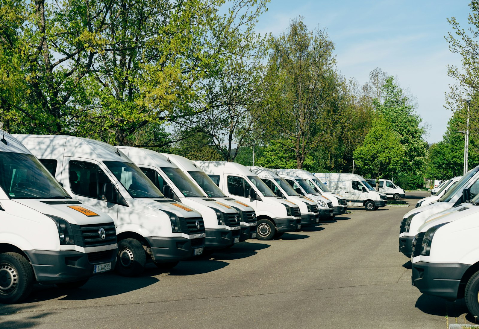 Salesforce Field Service mit Beyond Digital: Reihe weißer Servicetransporter auf einem Betriebshof