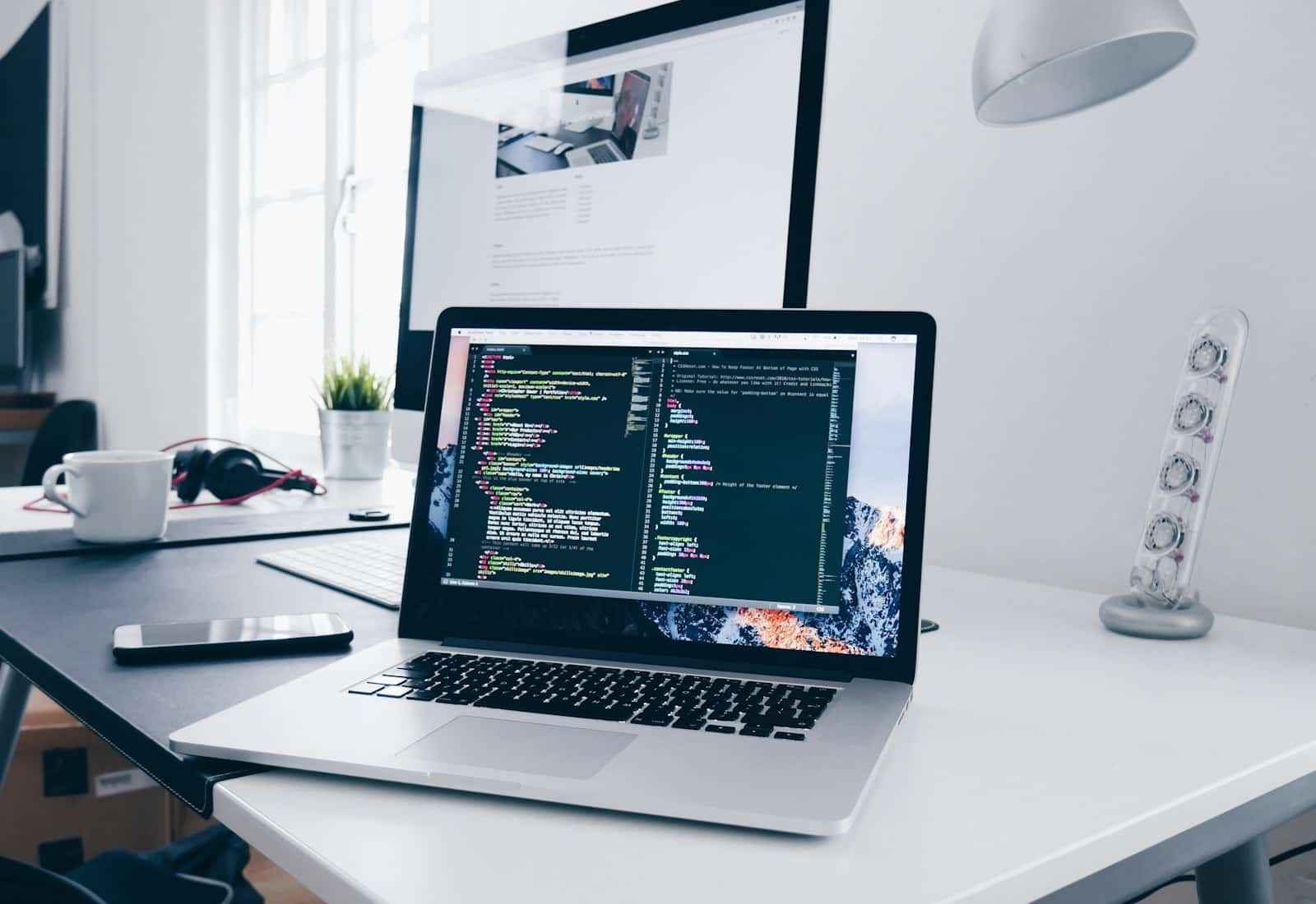 MuleSoft mit Beyond Digital: Laptop mit Programmcode auf dem Bildschirm an einem hellen Arbeitsplatz