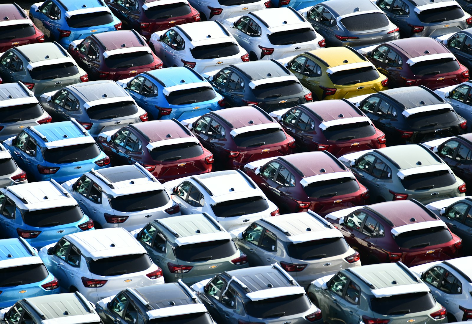 Salesforce Automotive Cloud mit Beyond Digital: Reihen neuer Autos in verschiedenen Farben auf einem großen Abstellplatz von oben