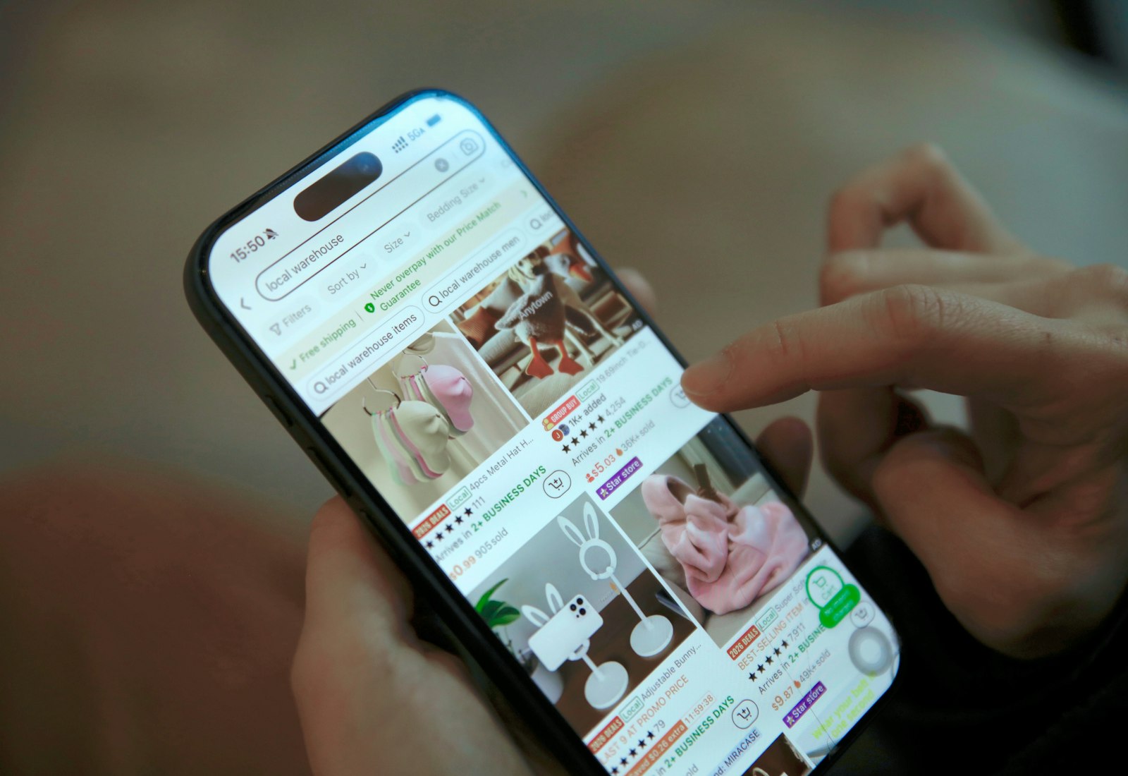 Salesforce Commerce Cloud mit Beyond Digital: Hand scrollt auf einem Smartphone durch einen Onlineshop mit Produktbildern
