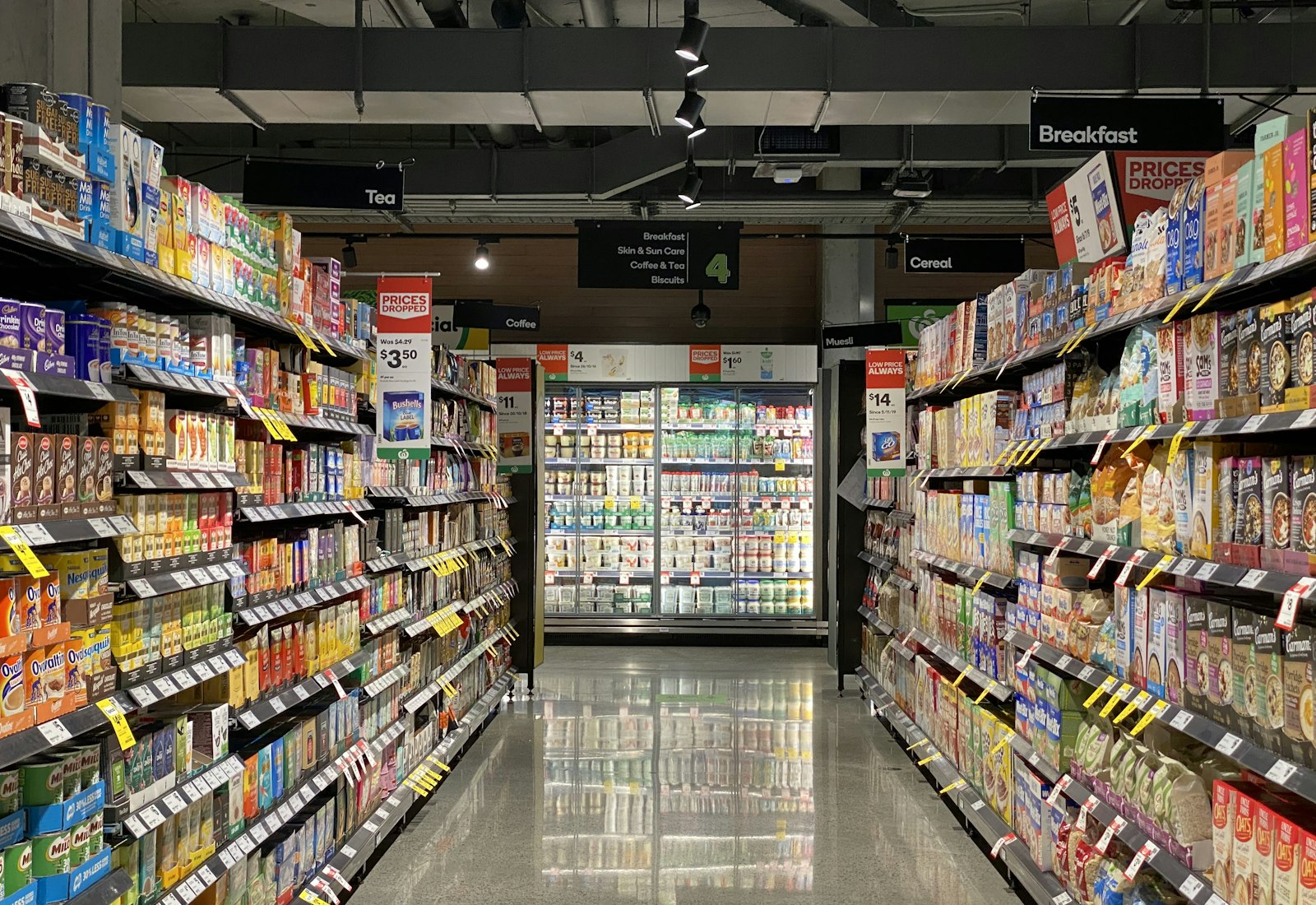 Salesforce Consumer Goods Cloud mit Beyond Digital: Langer Regalgang in einem Supermarkt mit gefüllten Regalen und Kühltheken im Hintergrund