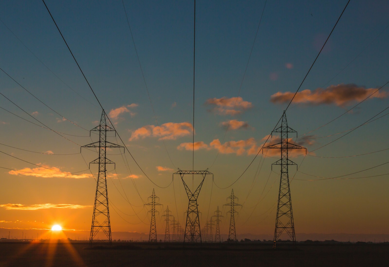 Salesforce Energy & Utilities Cloud mit Beyond Digital: Hochspannungsleitungen und Strommasten vor einem Sonnenuntergang