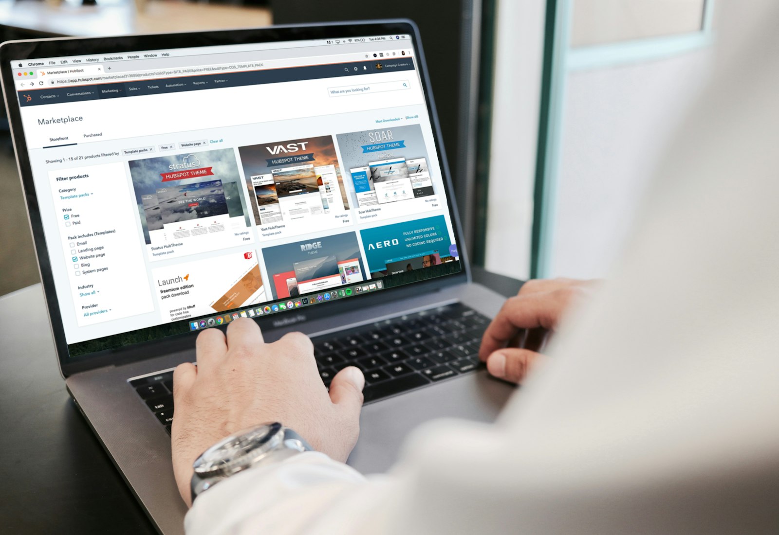 Salesforce Experience Cloud mit Beyond Digital: Person arbeitet an einem Laptop, auf dem eine Portalseite mit Produktübersicht und Filtern