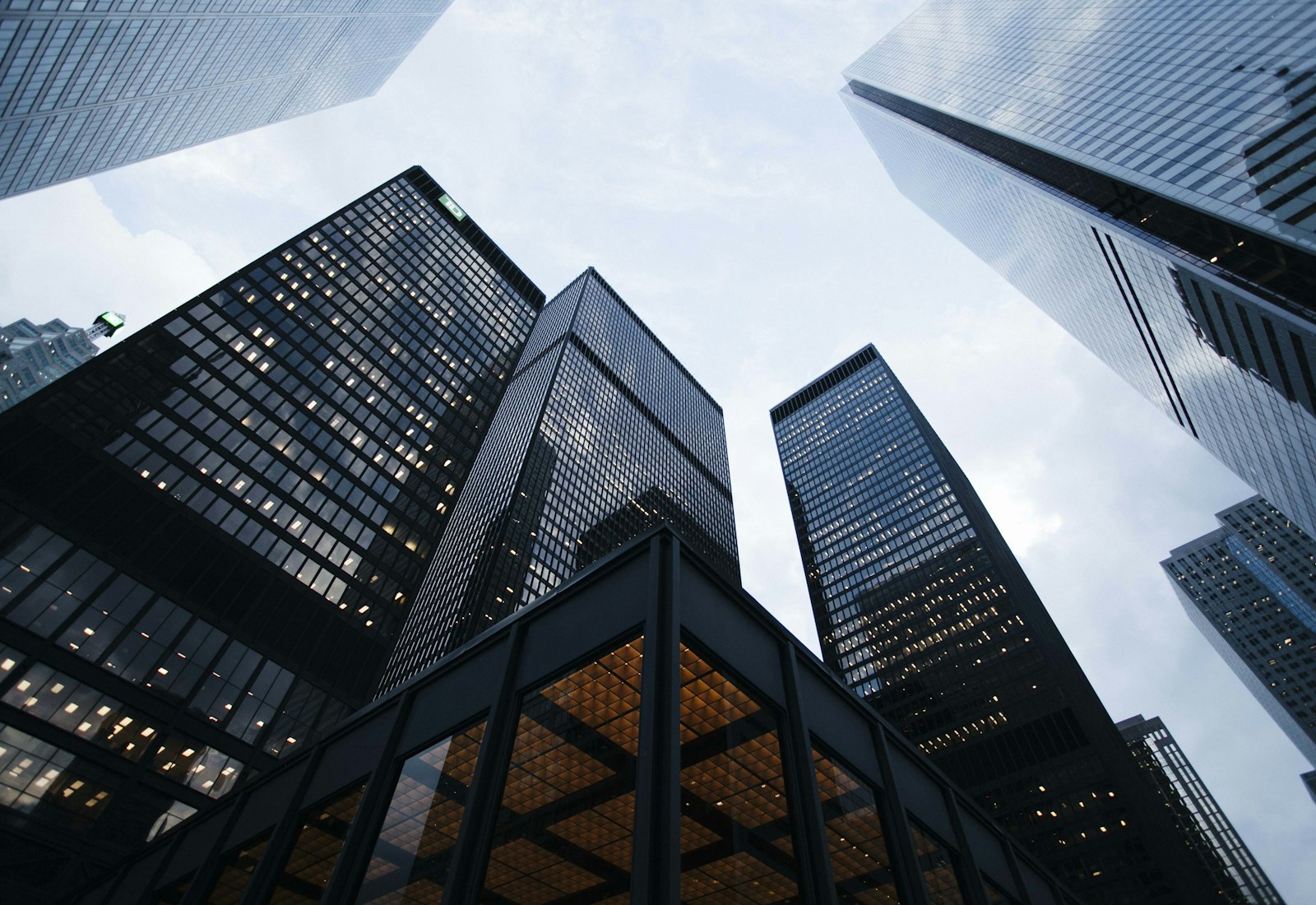 Salesforce Financial Services Cloud mit Beyond Digital: Dunkle Bürohochhäuser aus der Froschperspektive vor bewölktem Himmel