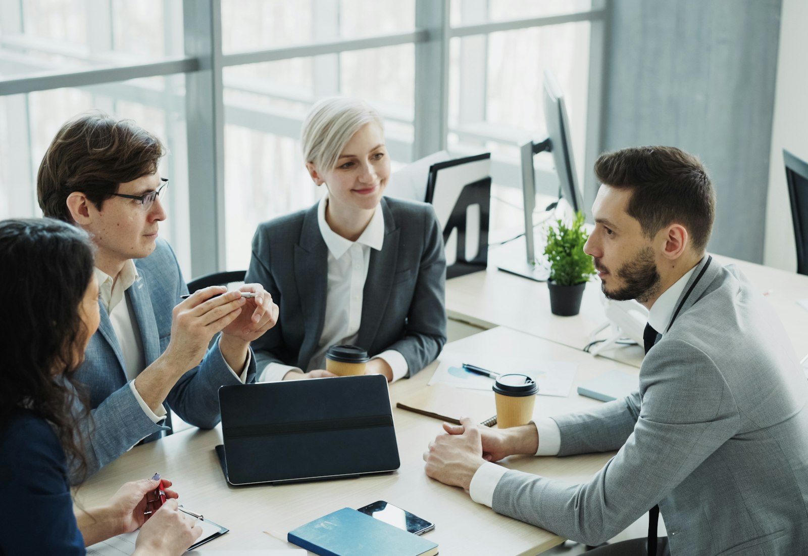 Salesforce Financial Services Cloud Einführung mit Beyond Digital: Vier Kolleginnen und Kollegen besprechen sich an einem Tisch in einem modernen Büro