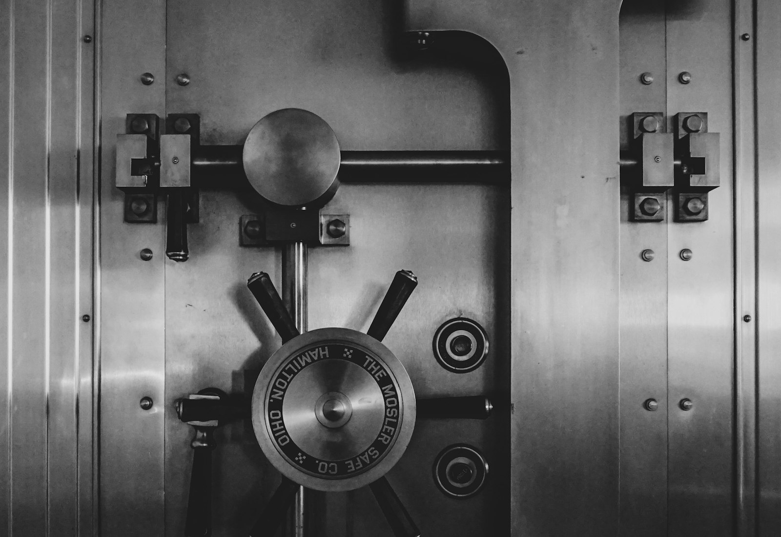 Salesforce Financial Services Cloud mit Beyond Digital: Schwere Tresortür aus Stahl mit großem Verschlussrad in Schwarz-Weiß