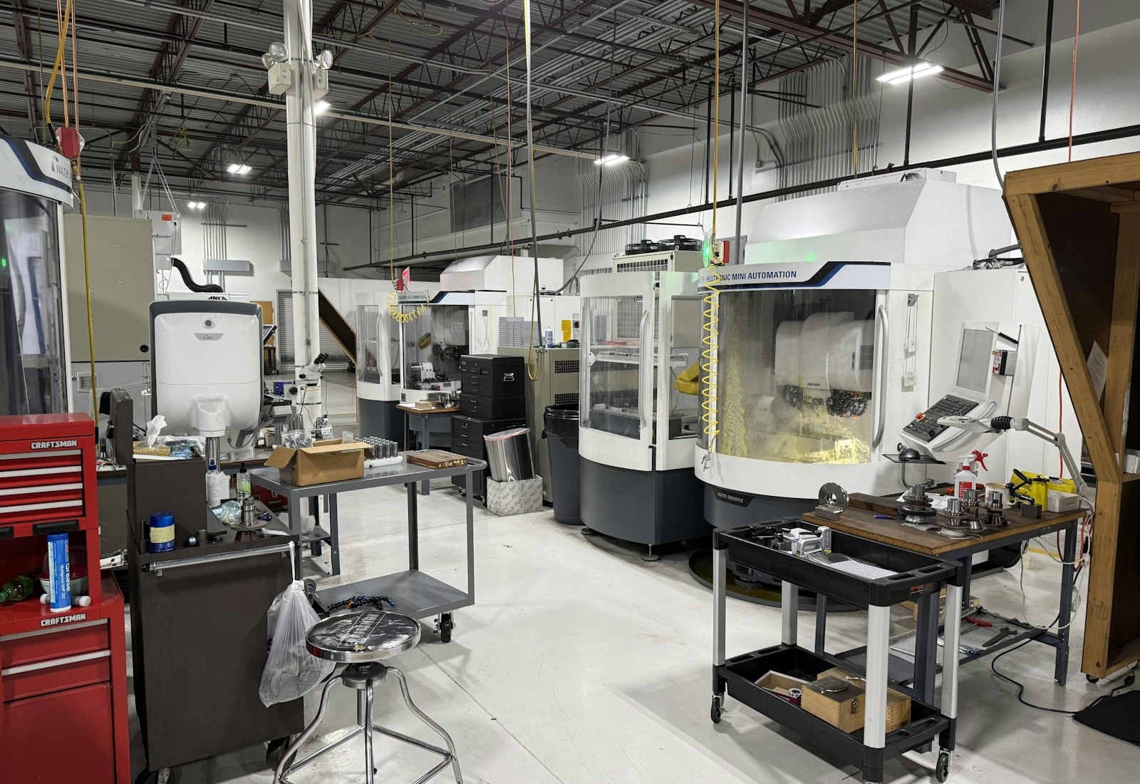 Salesforce Manufacturing Cloud Beratung von Beyond Digital: CNC-Bearbeitungszentren und Werkzeugwagen in einer hellen Fertigungswerkstatt