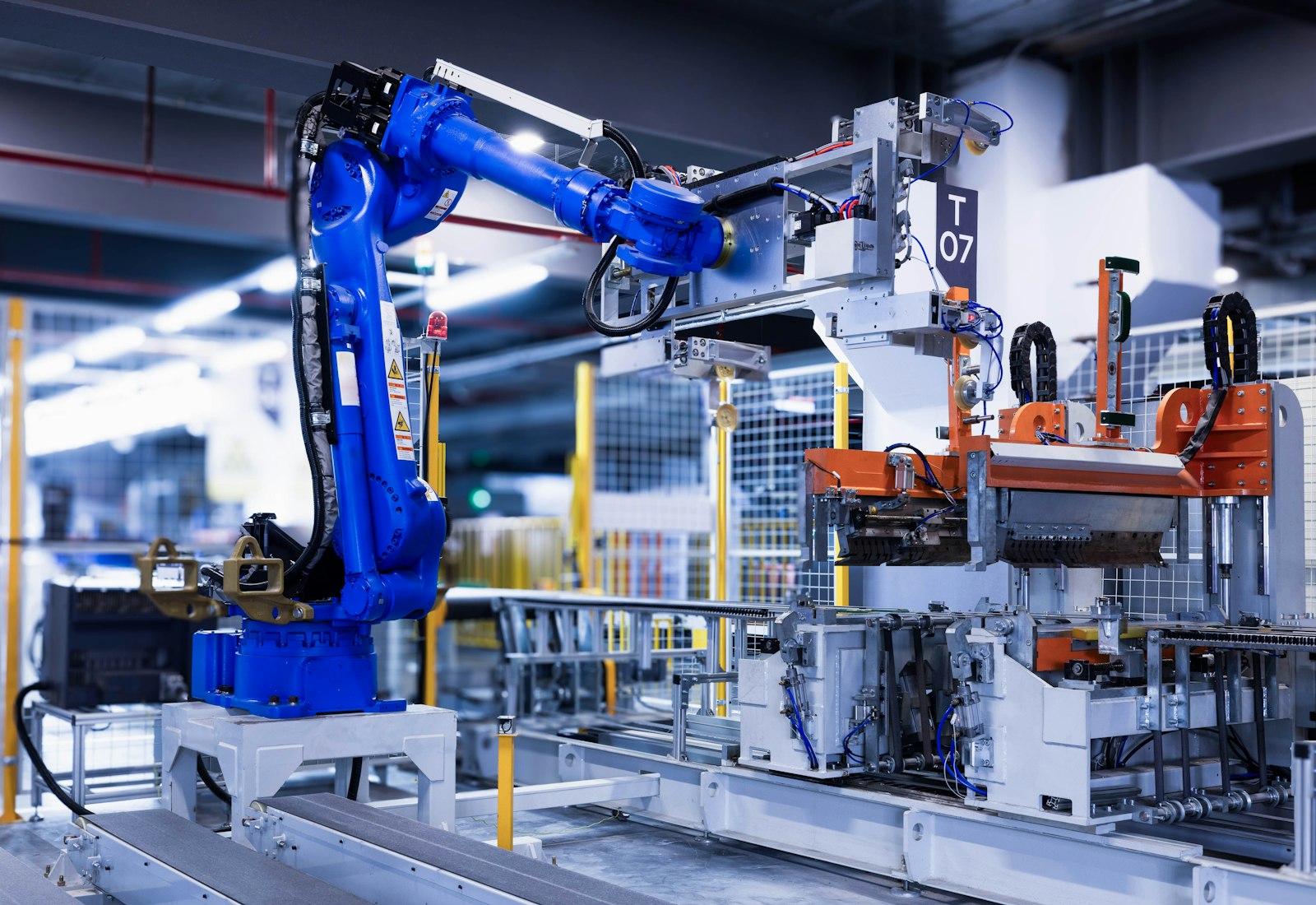 Salesforce Manufacturing Cloud mit Beyond Digital: Blauer Industrieroboter an einer automatisierten Fertigungslinie in einer hellen Halle