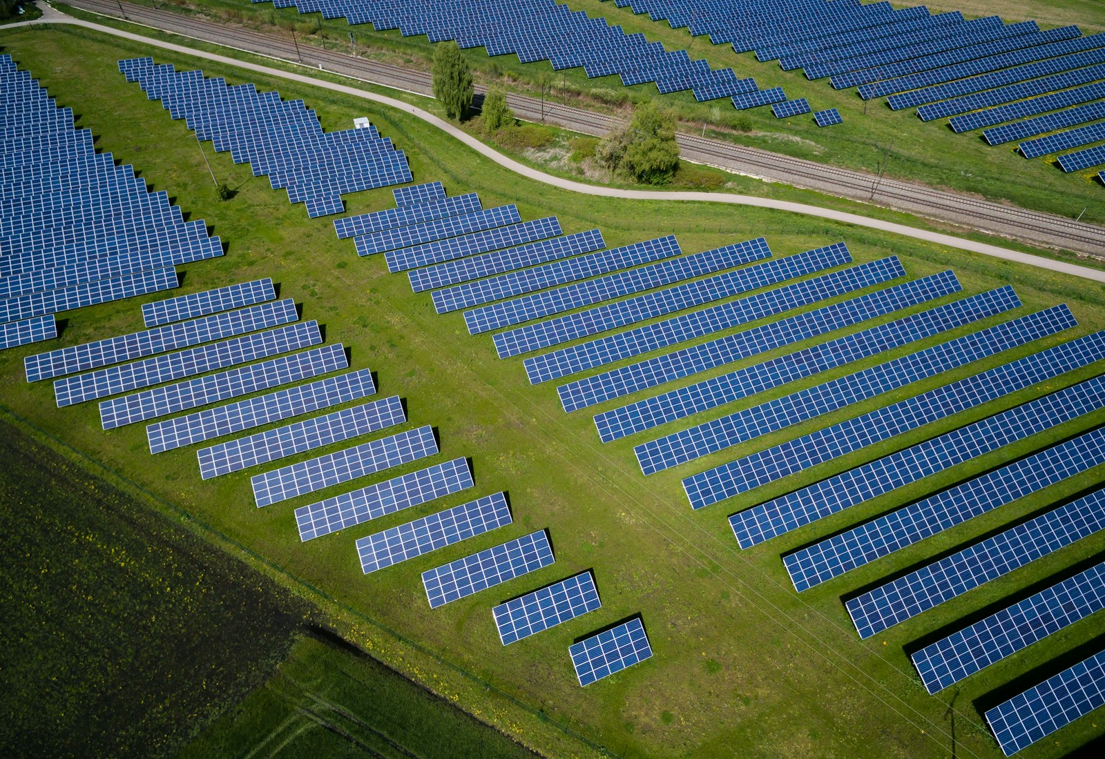 Salesforce Net Zero Cloud mit Beyond Digital: Luftbild eines Solarparks mit Reihen blauer Solarmodule auf einer grünen Wiese