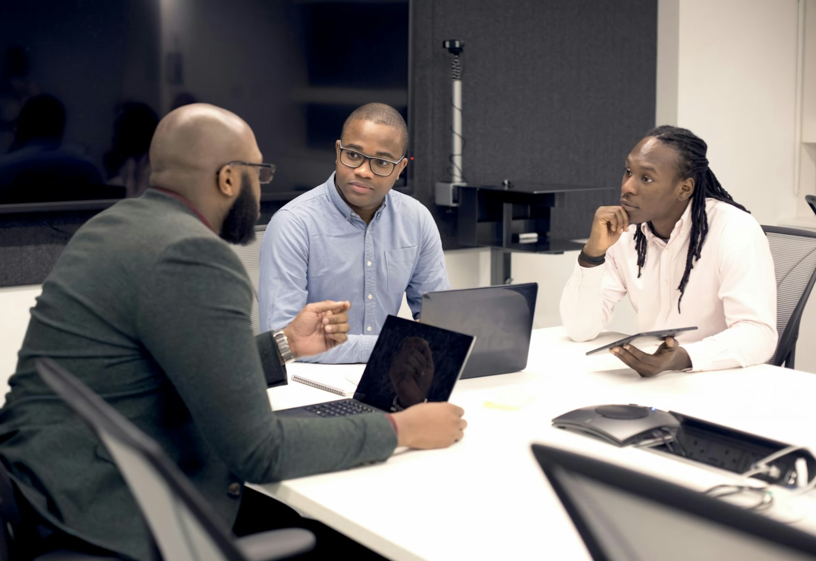 Salesforce Nonprofit Cloud mit Beyond Digital: Drei Personen besprechen sich an einem Tisch mit Laptops und Tablet