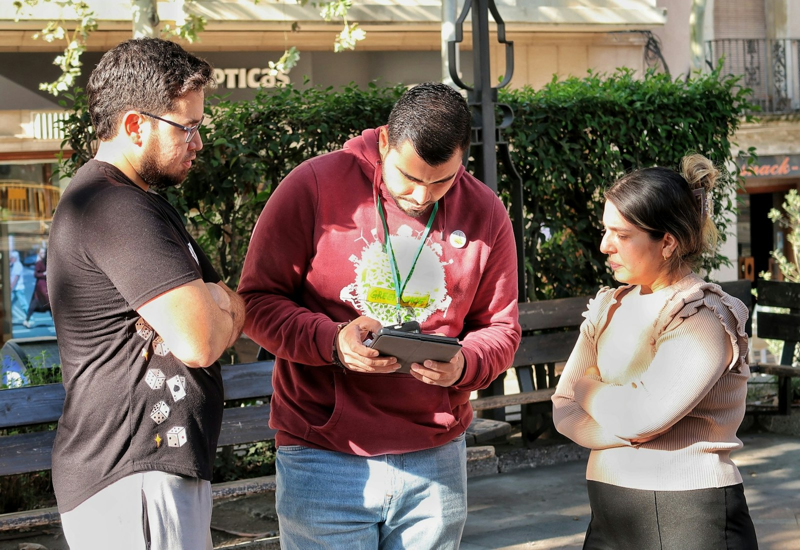 Salesforce Nonprofit Cloud mit Beyond Digital: Drei Personen schauen im Freien gemeinsam auf ein Tablet