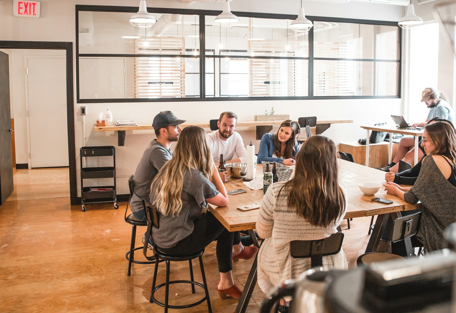 Salesforce Nonprofit Cloud mit Beyond Digital: Team einer Organisation sitzt an einem langen Tisch in einem hellen Büro und bespricht sich