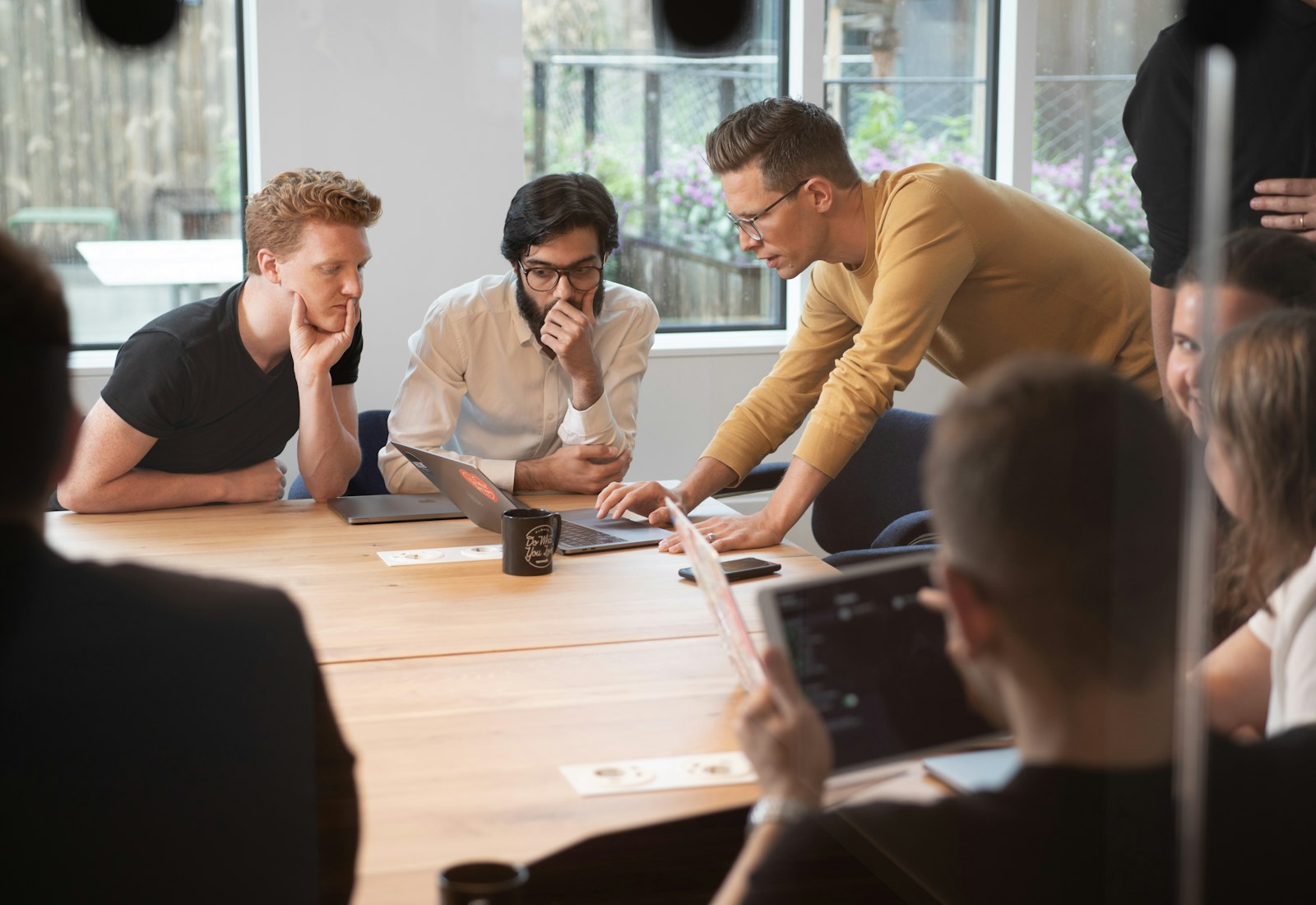 Salesforce Nonprofit Cloud Einführung mit Beyond Digital: Team arbeitet in einem Workshop gemeinsam an einem Holztisch mit Tablet und Notizen