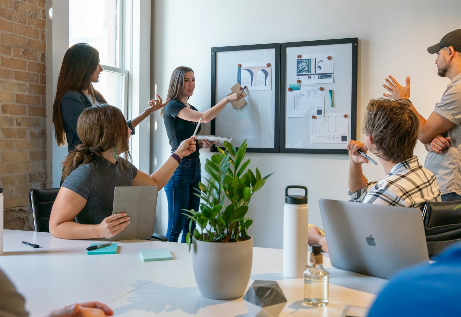 Salesforce Data Mask Einführung mit Beyond Digital: Gruppe bespricht sich an einem weißen Tisch, im Hintergrund eine Person am Whiteboard