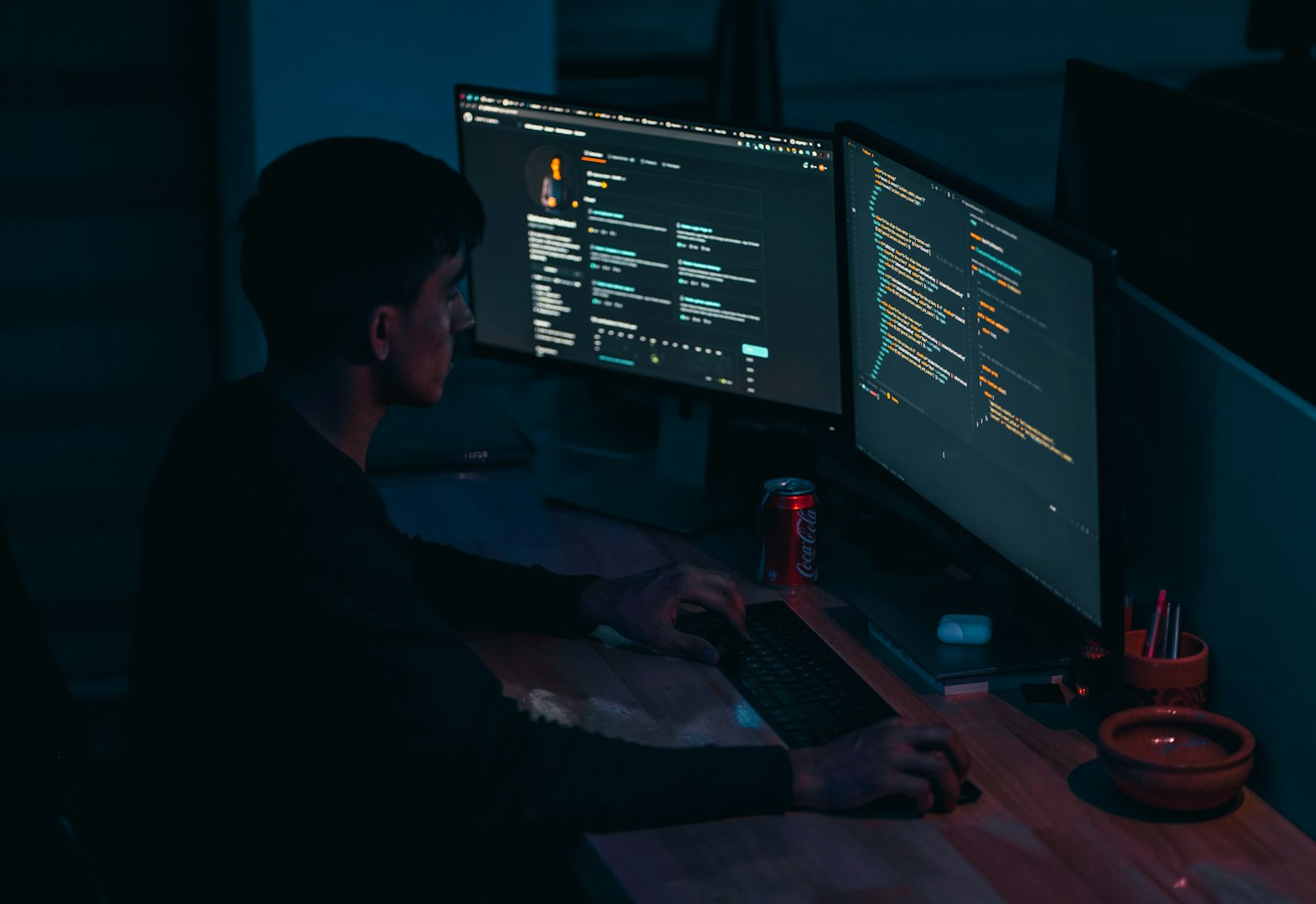 Salesforce Data Mask mit Beyond Digital: Entwickler arbeitet in einem abgedunkelten Raum an zwei Monitoren mit Code
