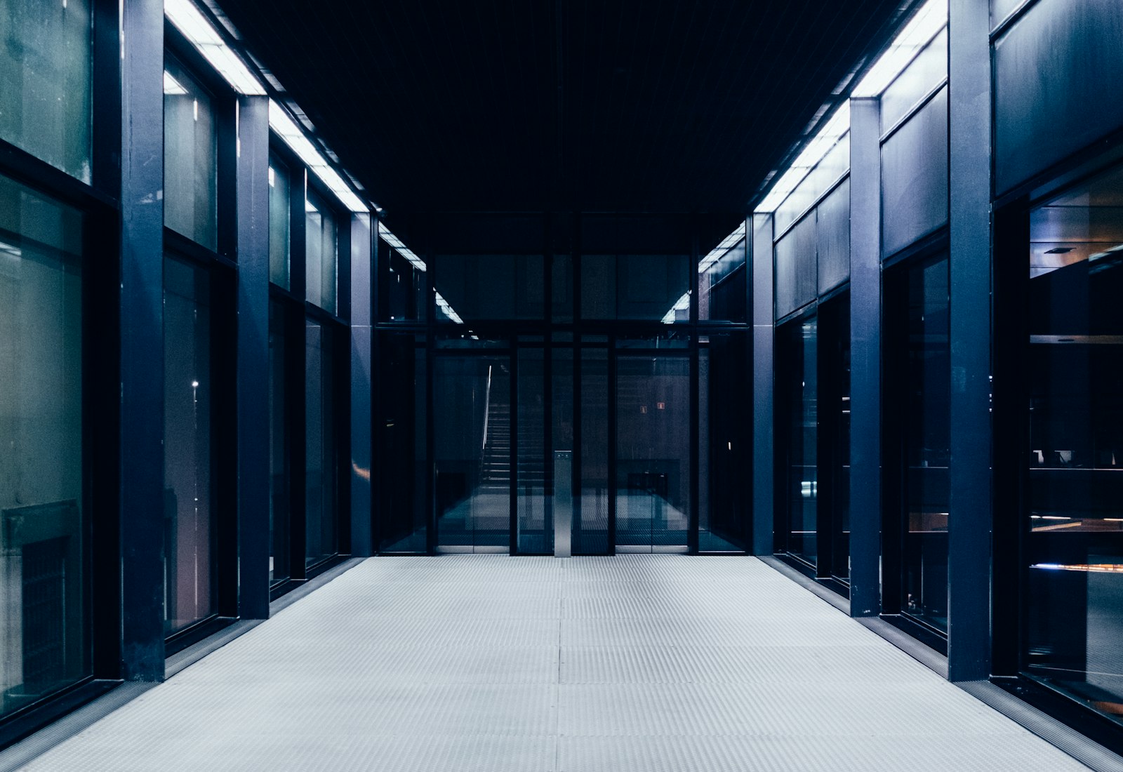 Salesforce Shield mit Beyond Digital: Langer, symmetrischer Gang zwischen dunklen Serverschränken mit Glastüren