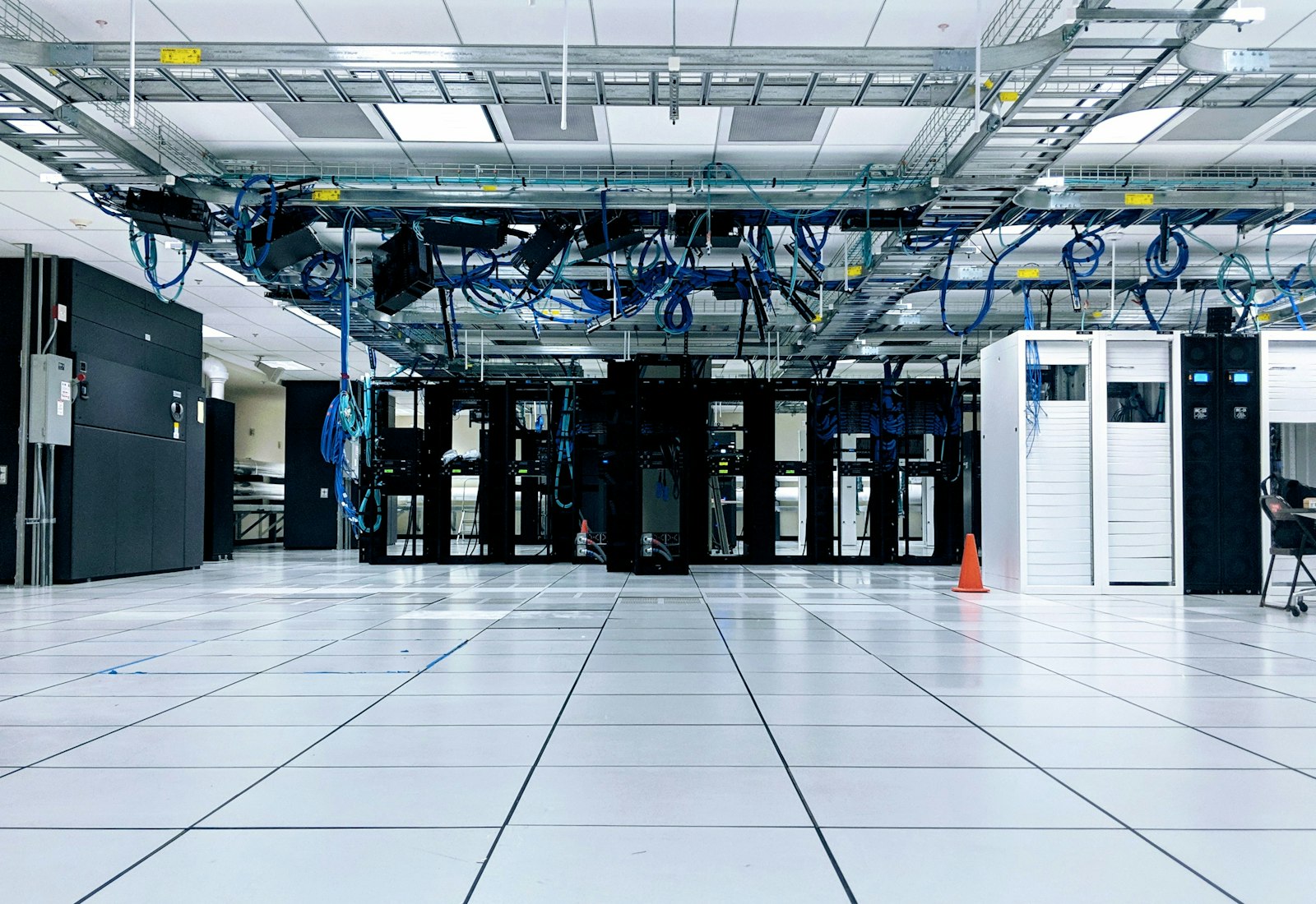 Salesforce Shield mit Beyond Digital: Heller Serverraum eines Rechenzentrums mit Reihen von Serverschränken und Kabeltrassen