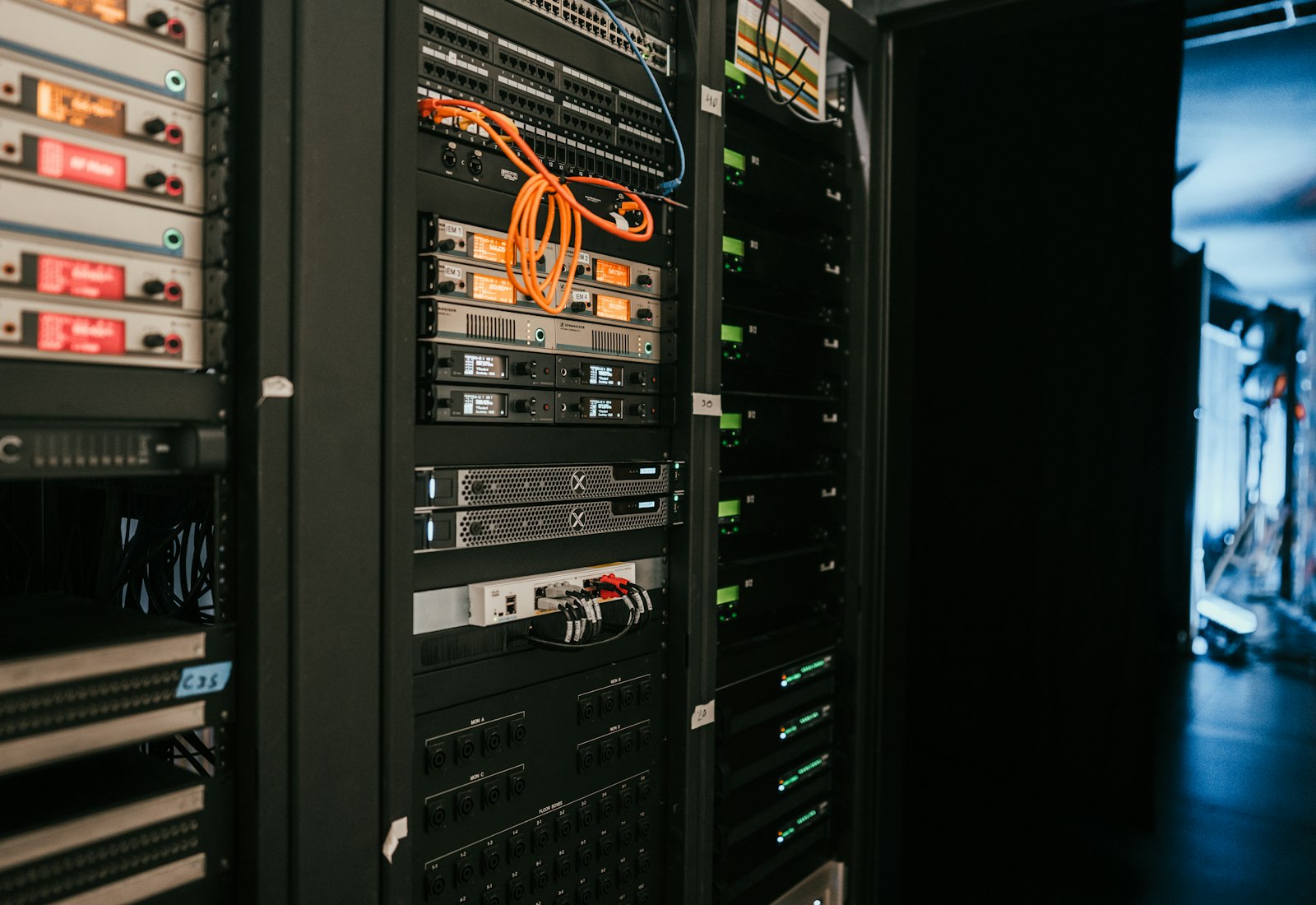 Salesforce Shield Beratung von Beyond Digital: Serverrack mit Netzwerkgeräten und Kabeln in einem dunklen Serverraum