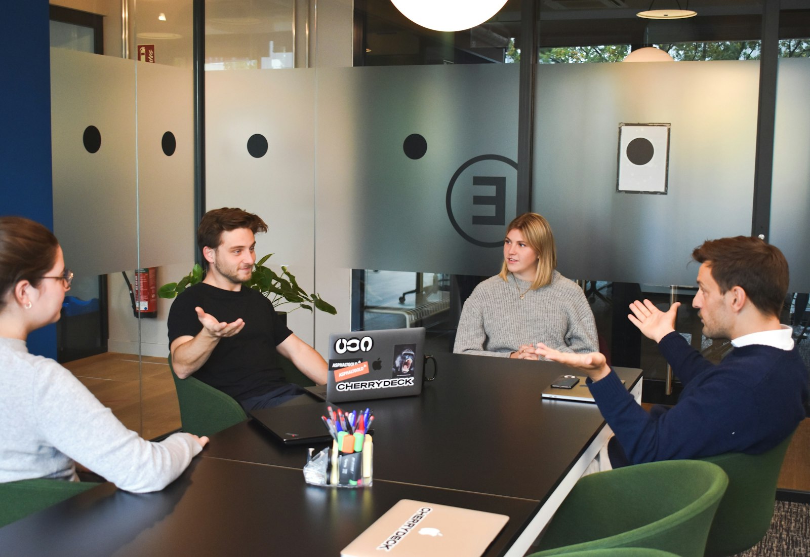Salesforce Shield Einführung mit Beyond Digital: Vier Personen besprechen sich an einem Konferenztisch in einem modernen Büro