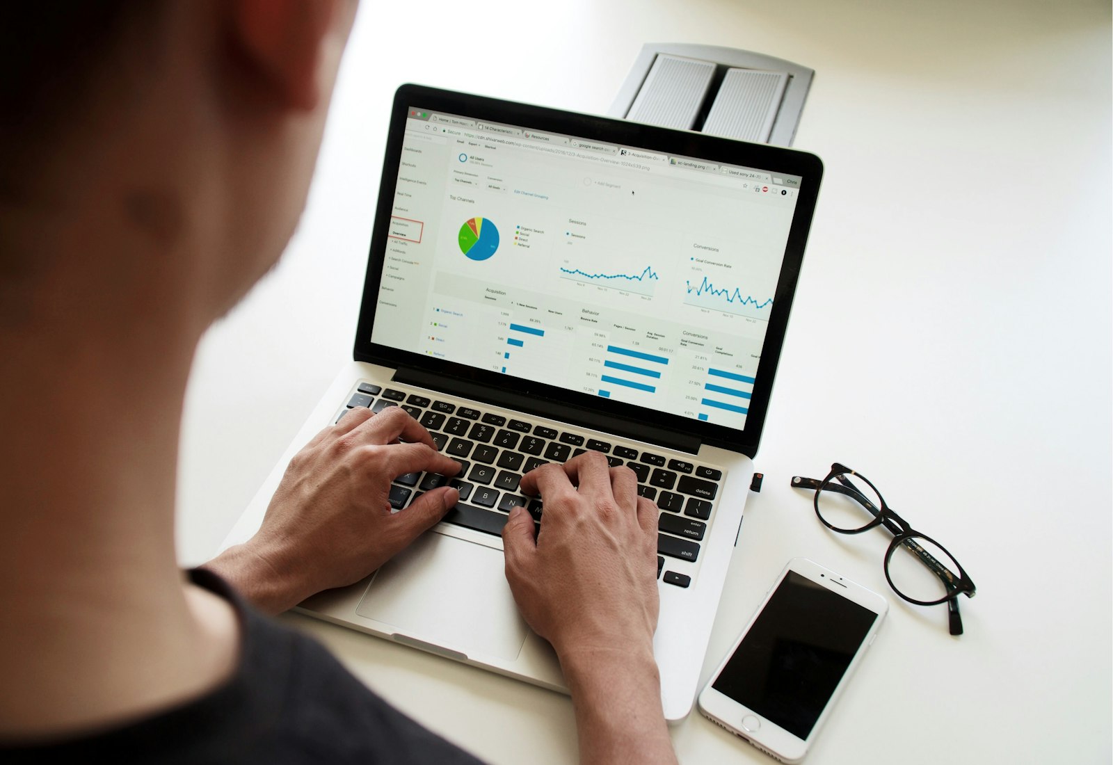 Tableau Salesforce mit Beyond Digital: Person arbeitet an einem Laptop mit Diagrammen und Kennzahlen, daneben Brille und Smartphone